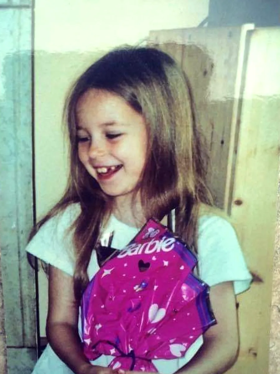 Anna enfant, souriante, tenant un cadeau