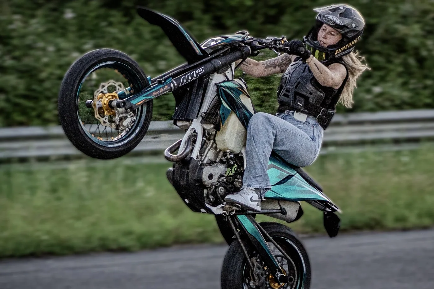 Anna Adella en équilibre sur la roue arrière de sa moto
